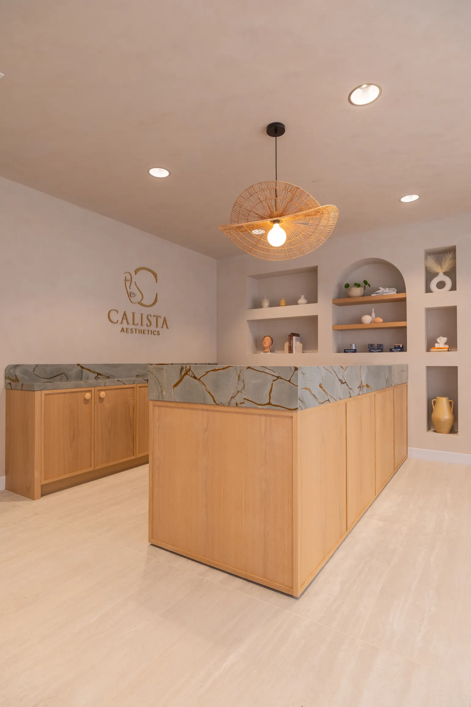 Calista reception area with a marble-accented wooden counter and softly lit display shelving.